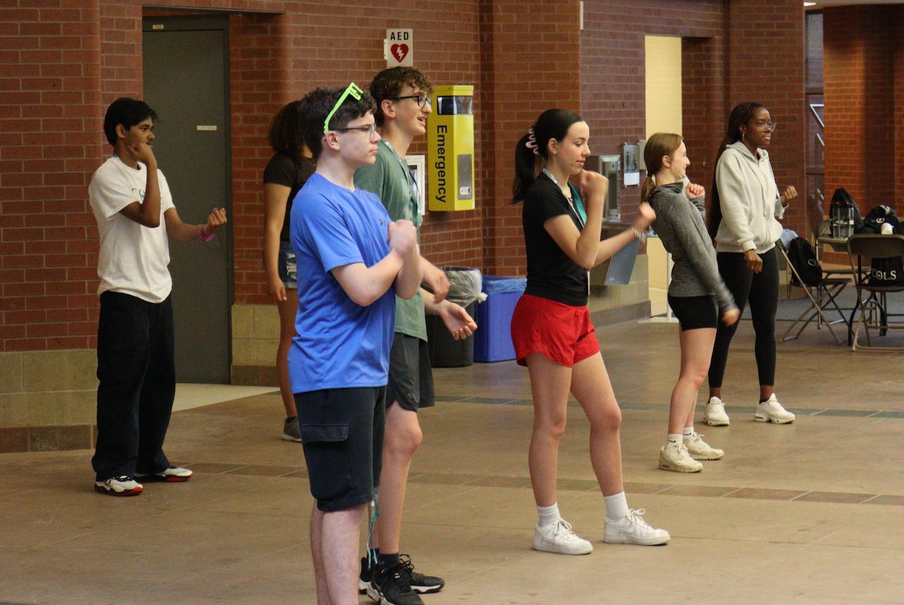 COLS ambassadors and staff dancing together in a brick-walled atrium
