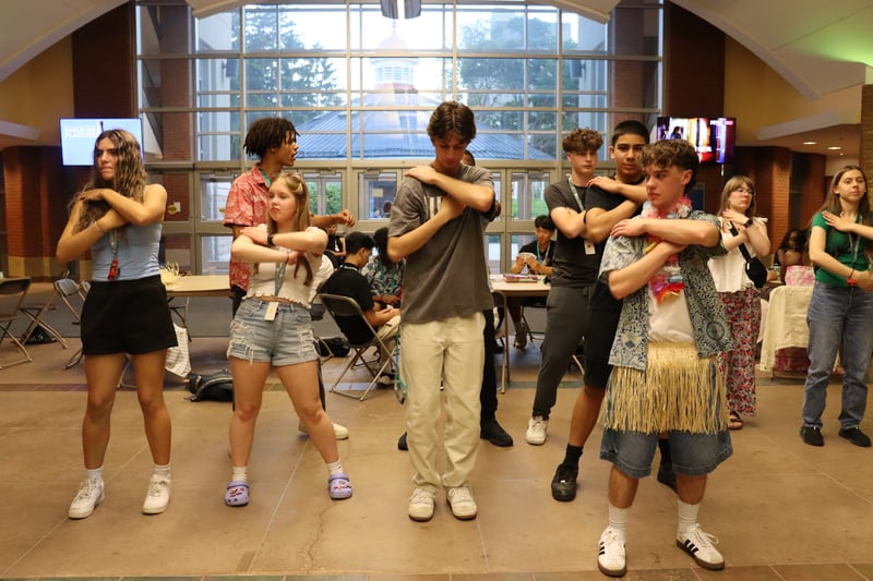 Ambassadors and staff dancing together in a bright hall