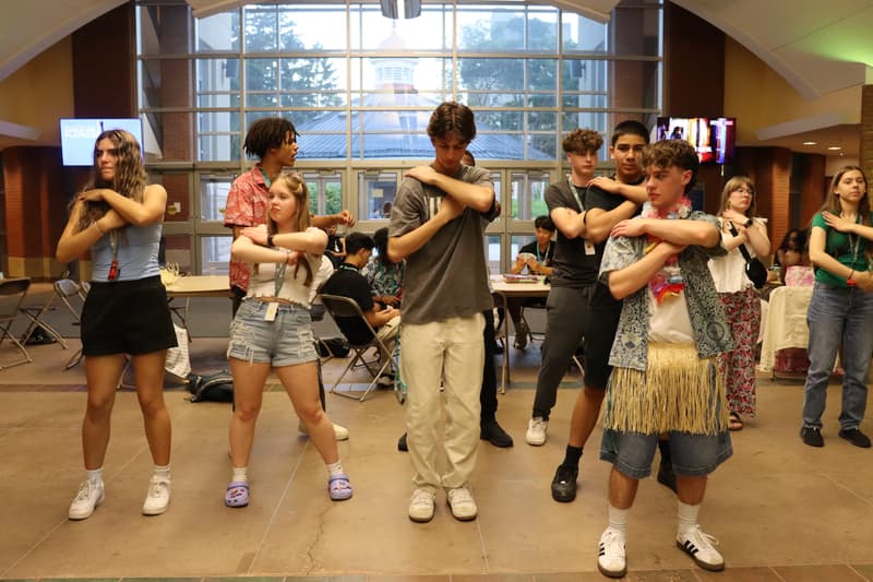 Ambassadors and staff dancing together in a bright hall